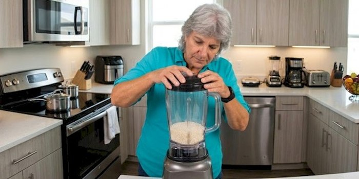 Anisa using a blender in her kitchen