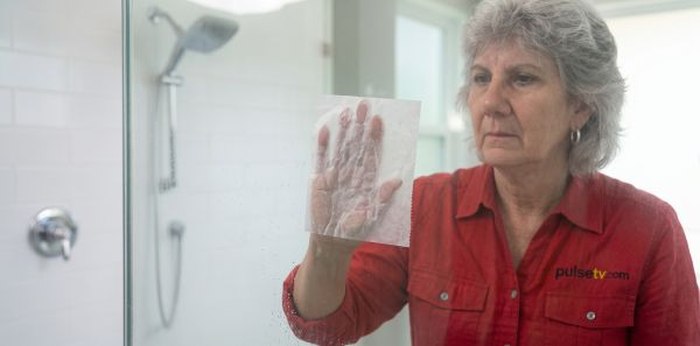 Anisa cleaning a glass shower door